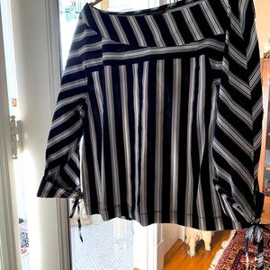 Blouse. Slightly off shoulder. Tied cuffs. Pleated back